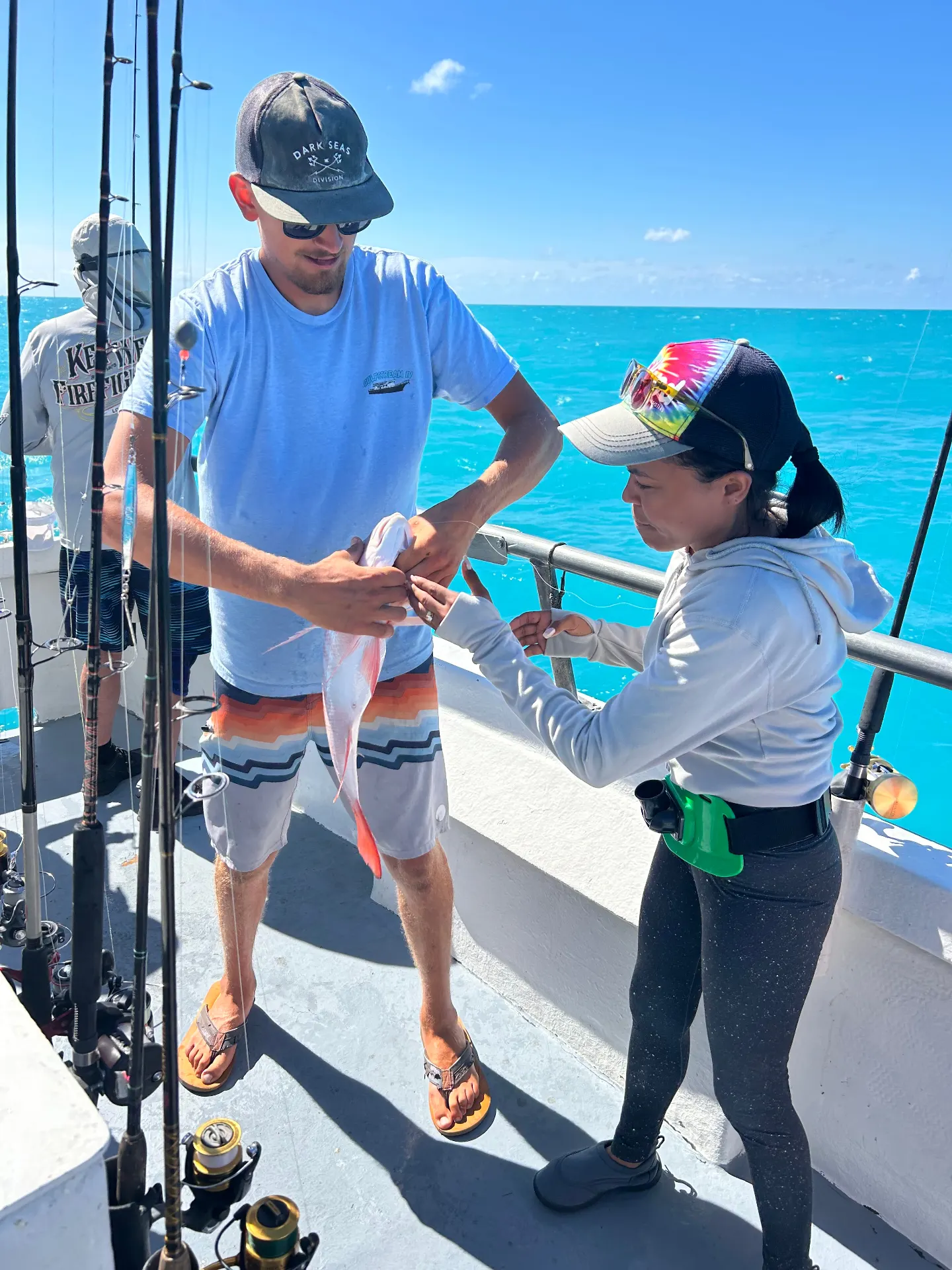 Gulfstream crew member helping guest unhook fish Key West party boat fishing