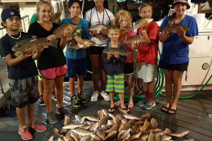 family holding up fish