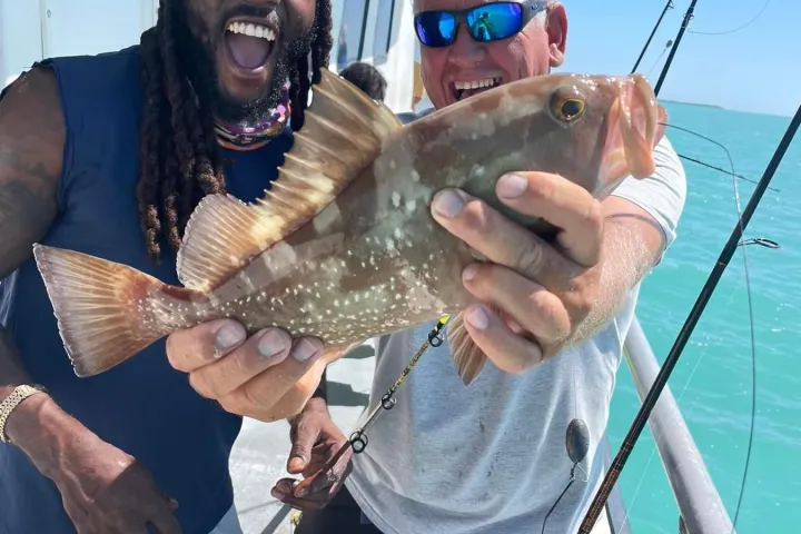 a person holding a fish on a boat