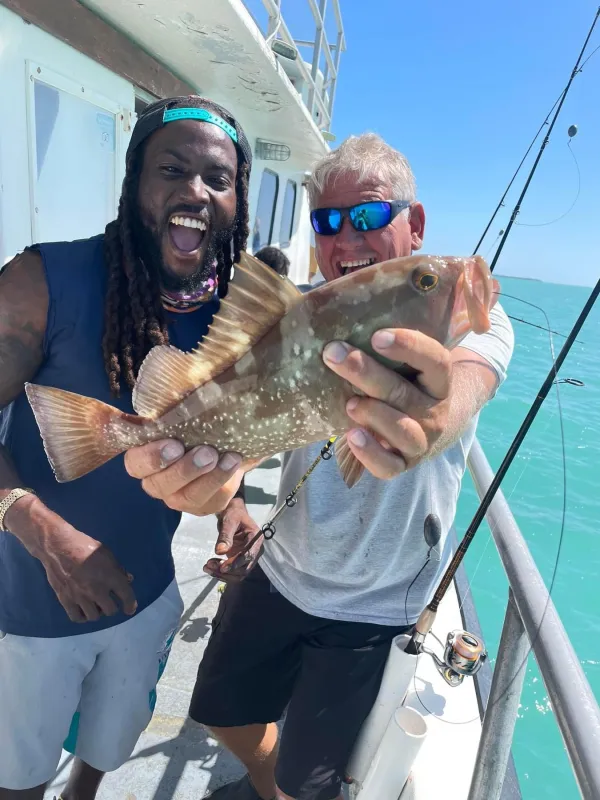 a person holding a fish on a boat