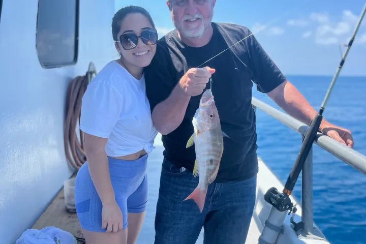 a person holding a fish on a boat