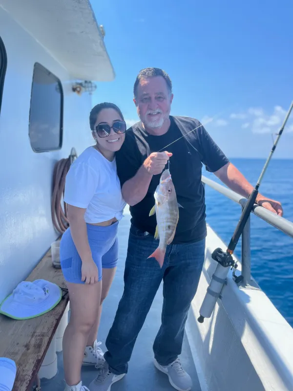 a person holding a fish on a boat