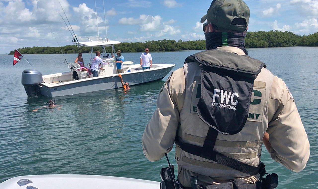 Key West Fising Regulations a man riding on the back of a boat in a body of water